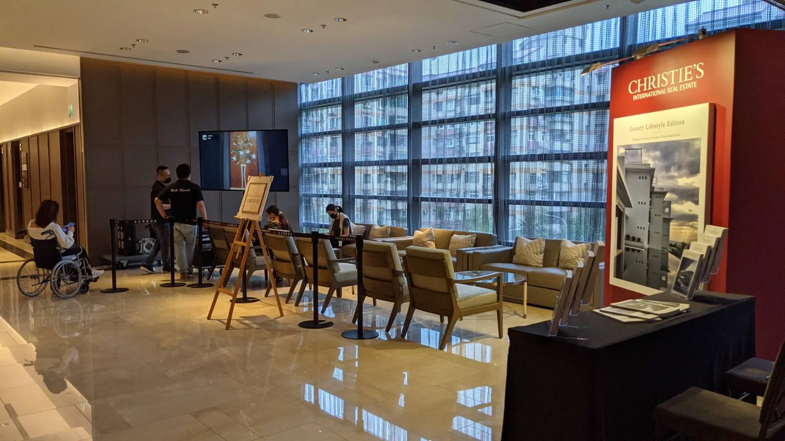 Christie's International Real Estate display at a luxury hotel venue — Luxury Lifestyle Edition catalogue stand beside a client lounge